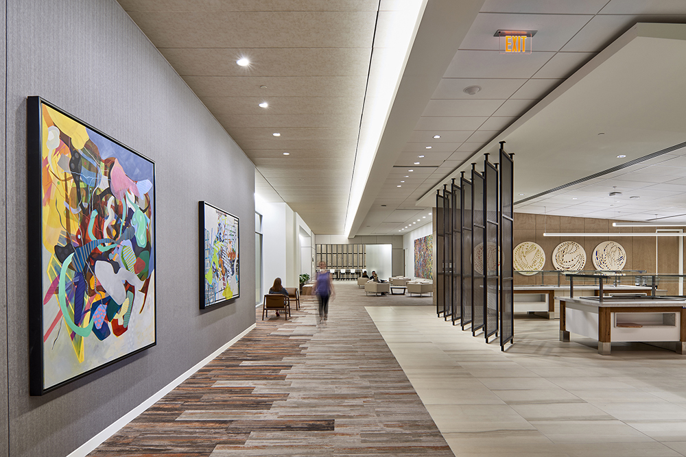 The design team capitalized on color, lighting, graphics and architectural elements to guide employees through the space to reinforce a sense locality while reinforcing the clients’ community brand. Use of architectural elements as wayfinding is a common element found throughout the campus – from the sculptural coffee bar to the lit forms at each end of the building. Both entrances to the eighth-floor feature foundational branded signage that underscores the company’s culture and values.